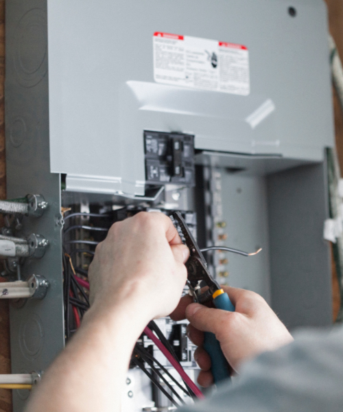 A man is working on an electrical panel