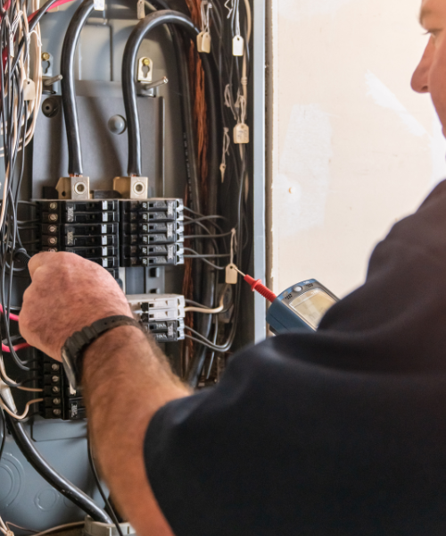 A man is working on an electrical panel